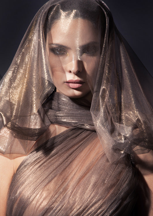 Sleeveless asymmetrical halter gown with caped open sleeve in fairy-spun bronze foiled silk tulle