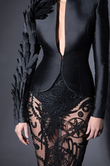 Plunging black tailored blazer in silk scuba with armour sleeve in laser-cut plumes and a silk tulle skirt swarming with Mesopotamian mythological creatures