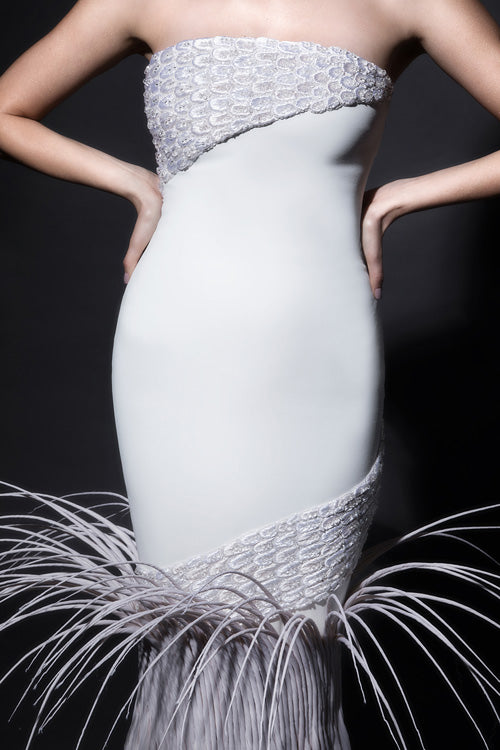 Sleeveless white silk crêpe gown with dramatic breakout mermaid tail in rippling silk organza, adorned with mermaid scales in 3D raffia threadwork, pearls, and crystals