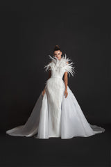 Strapless off-white liquid gazaar gown with voluminous floor sweeping overskirt; hand appliquéd with coq plumes and embroidered with Swarovski crystals