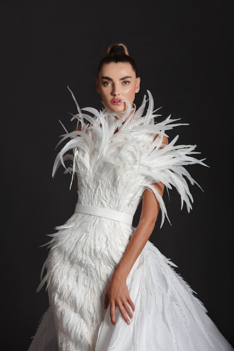 Off-white liquid gazaar gown with voluminous floor sweeping overskirt; hand appliquéd with coq plumes and embroidered with Swarovski crystals