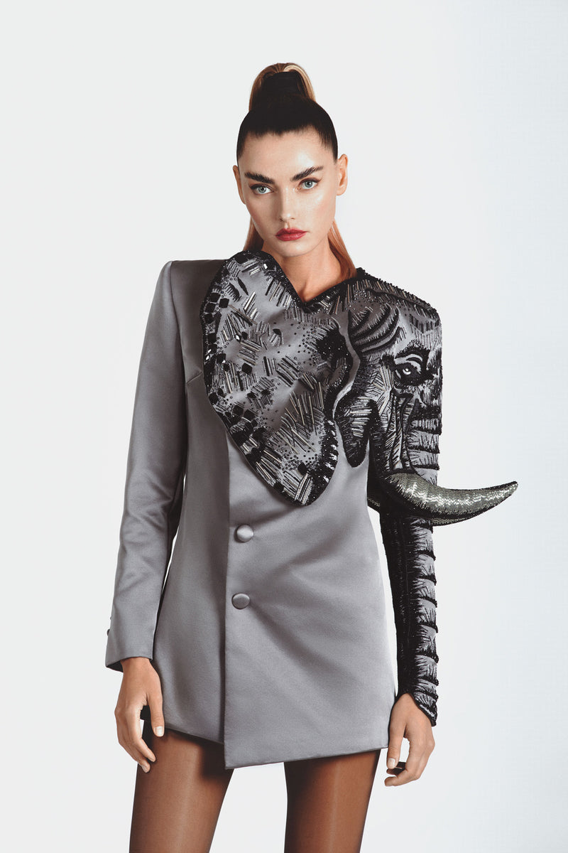 Double-breasted tailored jacket in grey double duchess silk satin featuring an elephant hand-embroidered with 3D metallic threadwork, crystals, glass beads and tusks in micro bugle beads