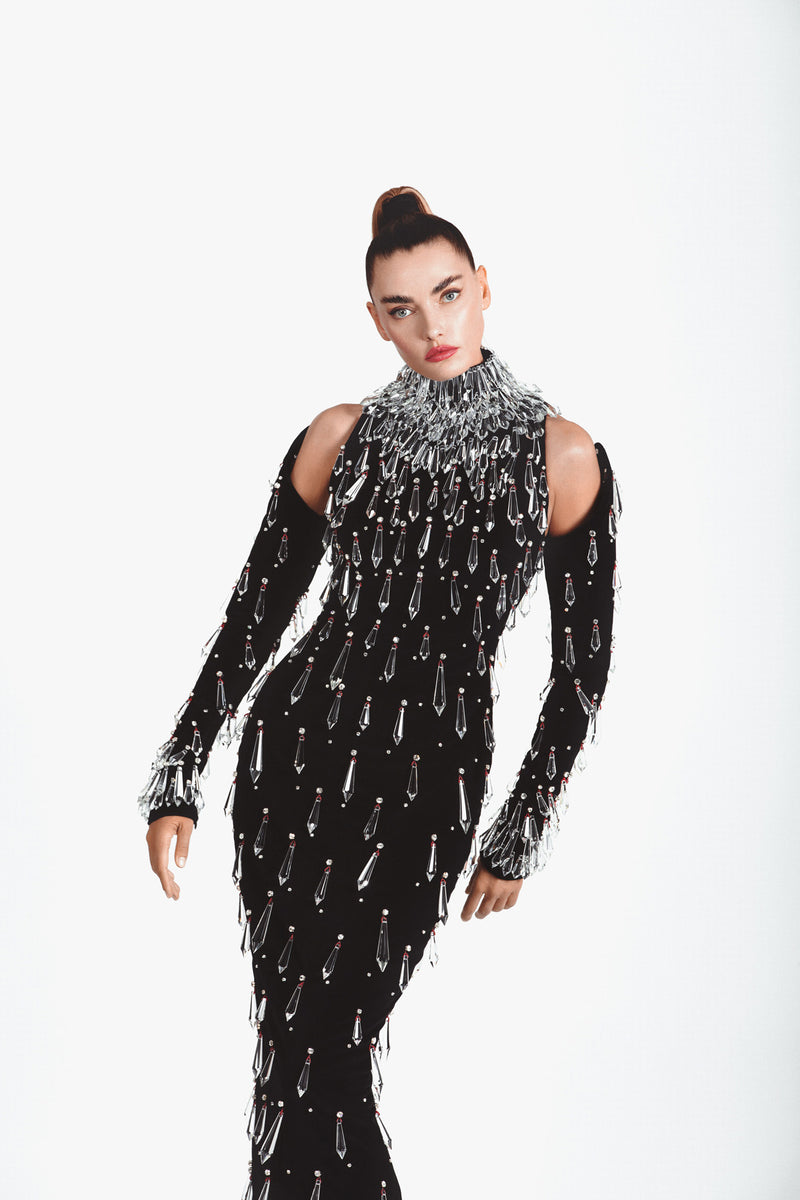Structured black velvet halter-neck dress embroidered with Swarovski stones and hanging chandelier crystal spikes worn with structured embroidered sleeves
