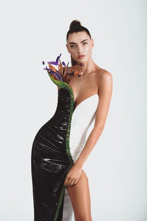 Strapless black & white liquid velvet dress with a sweetheart neckline and a thigh high slit, lavishly illustrated with a bird of paradise flower embroidered in 3D silk and metallic threadwork, glass beads, macro sequins, crystals and plumes