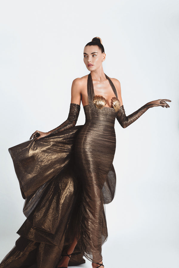 Slinky gown with an exploded bow-back ruffle in bronze foiled silk tulle featuring scallop shells handcrafted from solid brass and finished with hand-applied antique gold