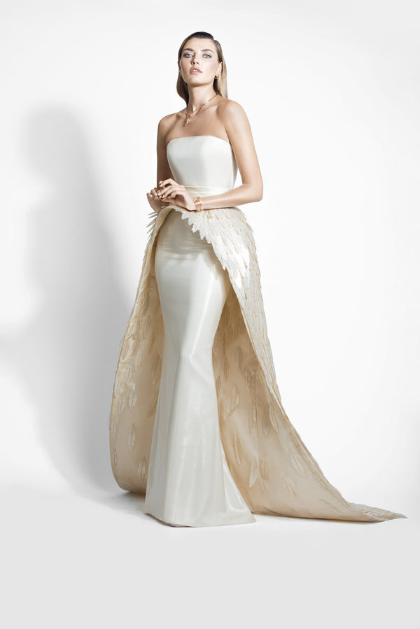 Ivory white lamé chiffon gown with dramatic overskirt overflowing with layered 3D laser-cut mother of pearl plumes