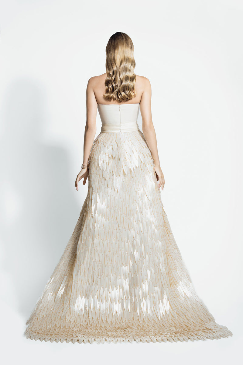Strapless ivory white lamé chiffon gown with dramatic overskirt overflowing with layered 3D laser-cut mother of pearl plumes