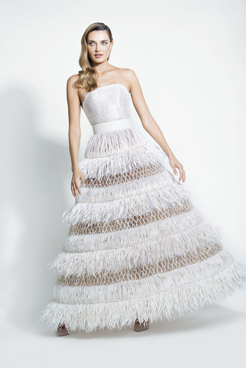 Off-white strapless ball gown fully embroidered with crisscross raffia threads, swarovski crystals, and layered twisted feathers