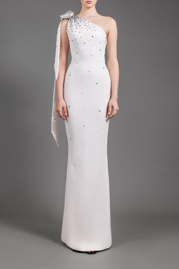 One-shoulder white crêpe dress embroidered with black crystals and bow detail