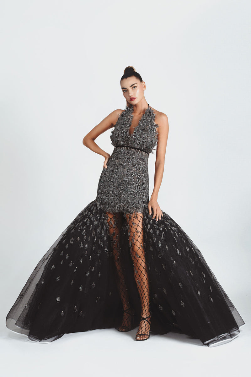 Sculptural dress with a deep plunging neckline in structured netting and layered polka dot plumage. Worn with fishnet stockings adorned with crystals and feathers